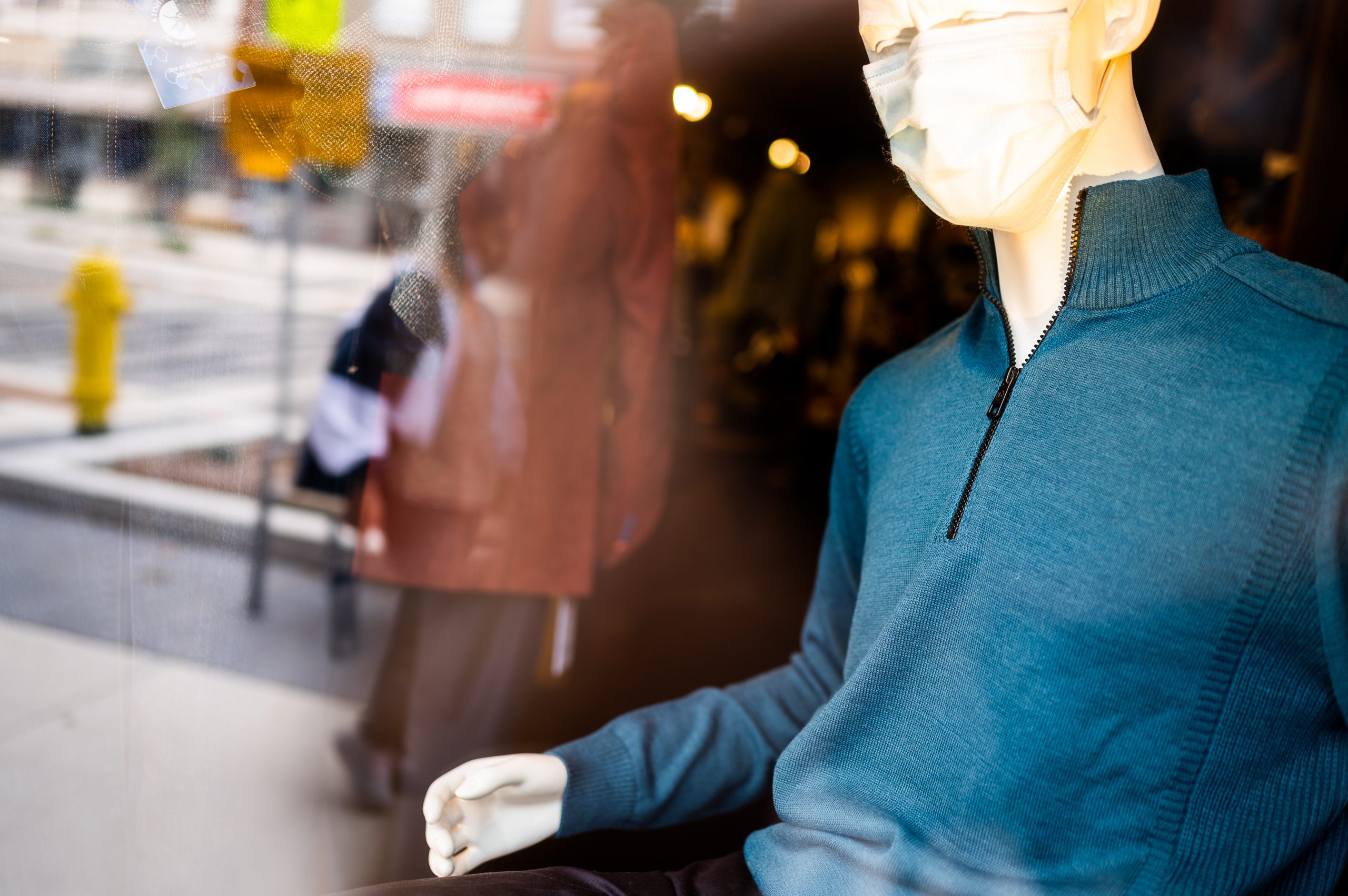 A green sport coat over a dress shirt on a rack of items in-store.