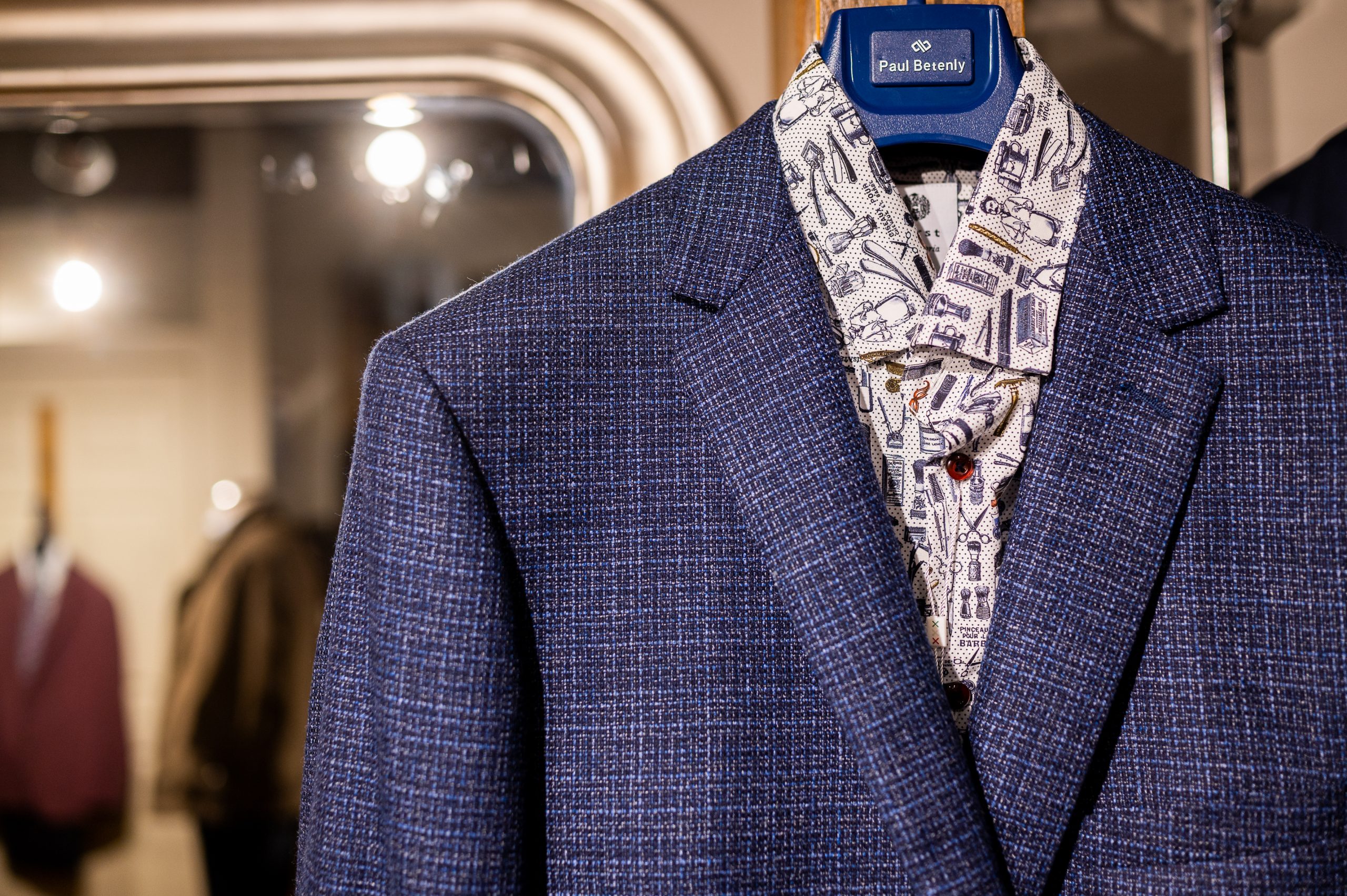 A display outside of the Taylor and Co store. A grey sport coat over a fun dress shirt, with purple pants.